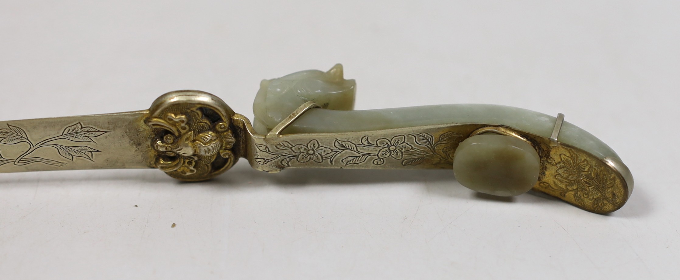 A Chinese celadon jade belt hook handled paperknife, the 19th century belt hook 8.2 cm long, total length 26.5 cm